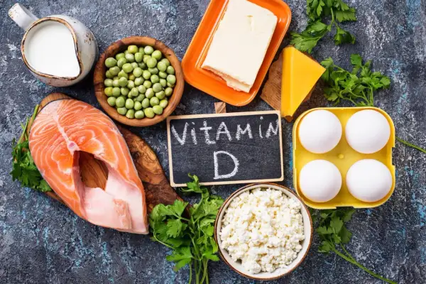 Ingredienti per come prendere la vitamina D: salmone, uova, latte, formaggio, piselli, burro e prezzemolo.