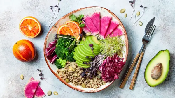Piatto colorato con quinoa, broccoli, avocado, ravanelli, arance rosse e germogli. Ideale per una dieta priva di scorie cosa mangiare.